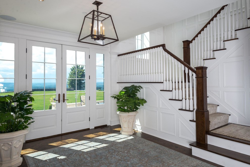 Huge transitional dark wood floor and brown floor foyer photo with white walls and a white front door