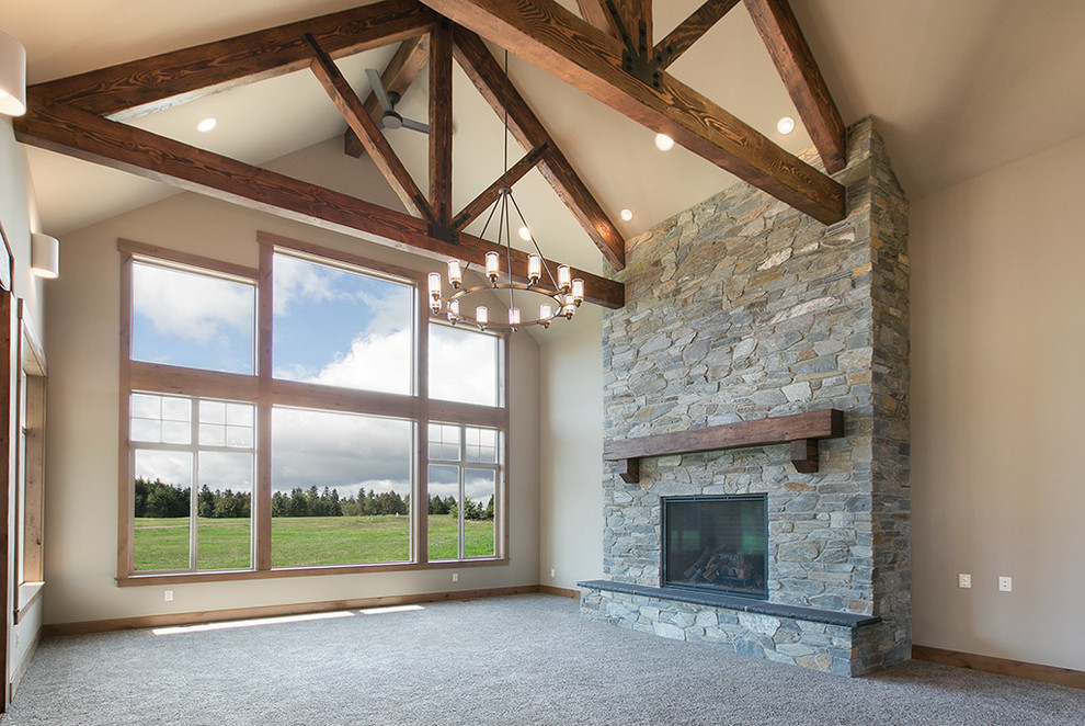 Photo of a large country open concept living room in Seattle with grey walls, carpet and a stone fireplace surround.