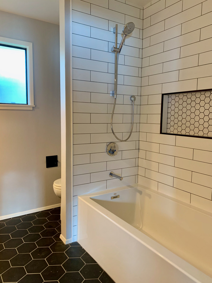 Inspiration for a mid-sized midcentury bathroom in Seattle with an alcove tub, white tile, grey walls, black floor, flat-panel cabinets, medium wood cabinets, an alcove shower, a two-piece toilet, subway tile, porcelain floors, engineered quartz benchtops, a shower curtain and white benchtops.