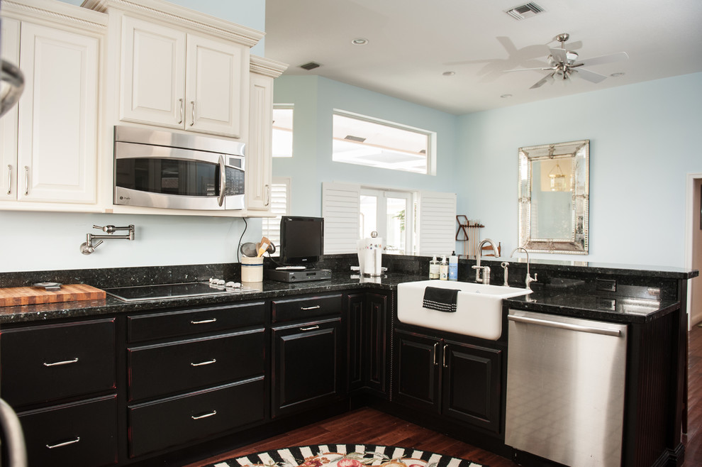 Large transitional u-shaped dark wood floor eat-in kitchen photo in Miami with a farmhouse sink, flat-panel cabinets, black cabinets, granite countertops, blue backsplash, stainless steel appliances and a peninsula