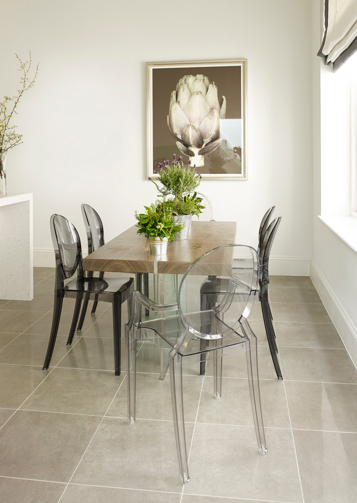 This is an example of a contemporary separate dining room in London with white walls.