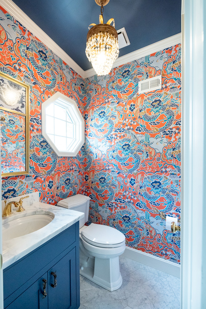 Small traditional powder room in Kansas City with shaker cabinets, blue cabinets, a two-piece toilet, multi-coloured walls, marble floors, an undermount sink, engineered quartz benchtops, grey floor and white benchtops.
