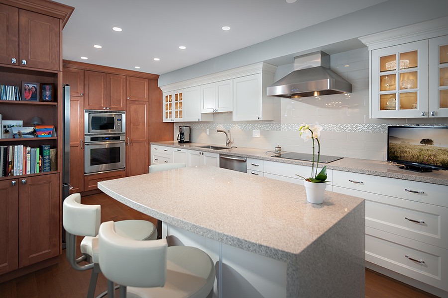 Mid-sized transitional galley dark wood floor kitchen photo in Vancouver with dark wood cabinets, granite countertops, white backsplash, stainless steel appliances and an island