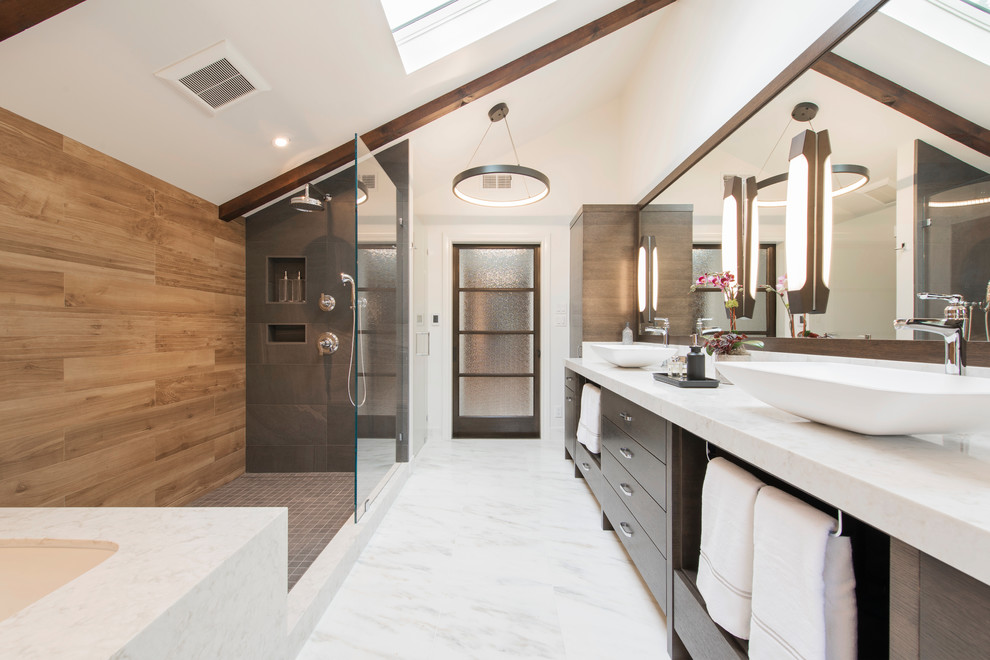 Inspiration for a large contemporary master bathroom in San Francisco with flat-panel cabinets, dark wood cabinets, an undermount tub, a corner shower, a wall-mount toilet, brown tile, porcelain tile, white walls, marble floors, a vessel sink, engineered quartz benchtops, white floor and an open shower.