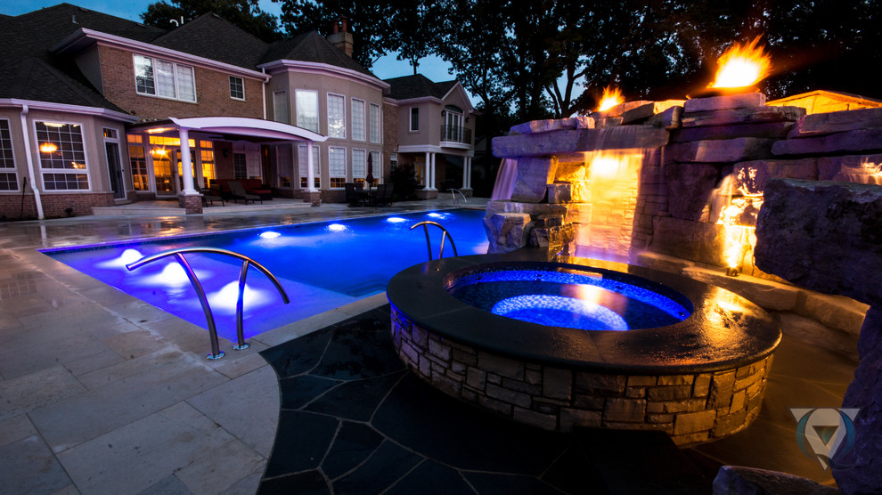 Example of a large mountain style backyard stone and rectangular natural pool fountain design in Chicago