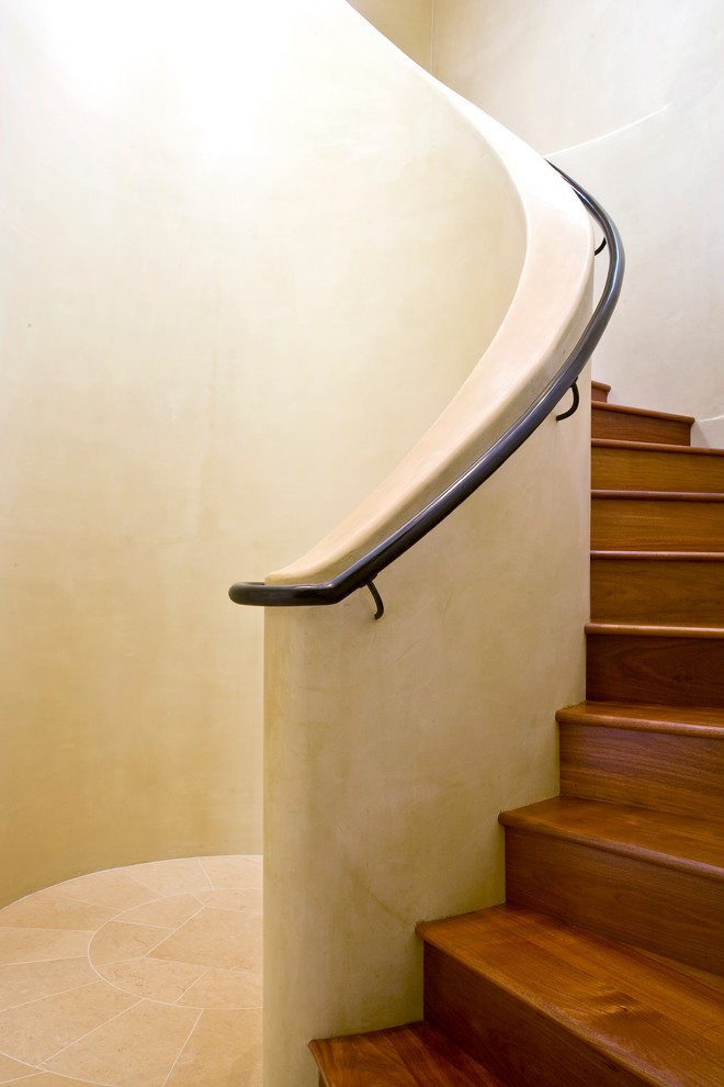 Photo of a large tropical wood spiral staircase in Santa Barbara with wood risers.