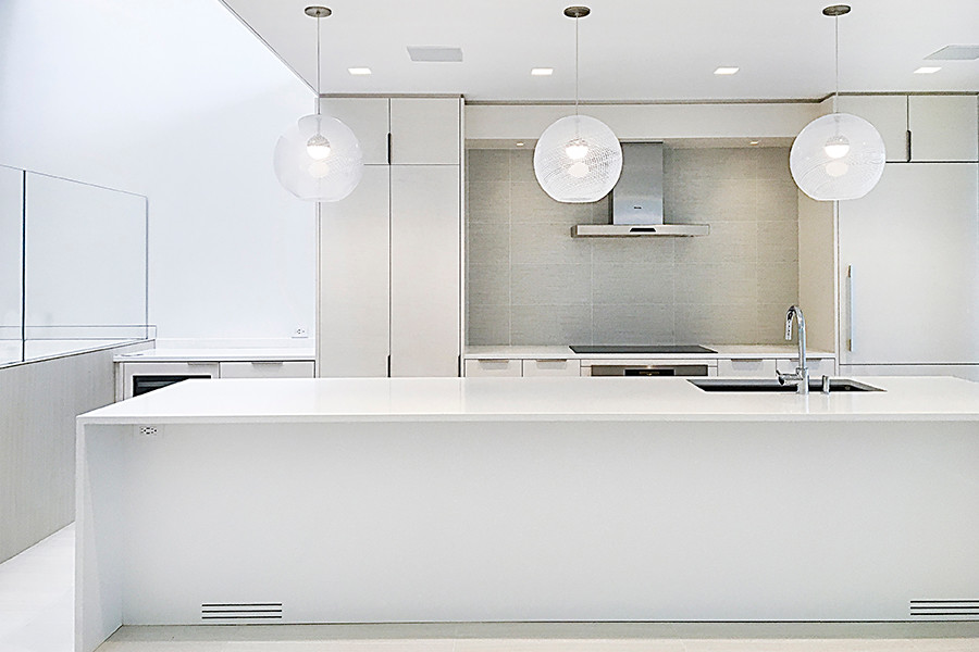 Design ideas for a small contemporary galley eat-in kitchen in New York with an undermount sink, flat-panel cabinets, white cabinets, quartzite benchtops, grey splashback, porcelain splashback, panelled appliances, porcelain floors, with island, white floor and white benchtop.