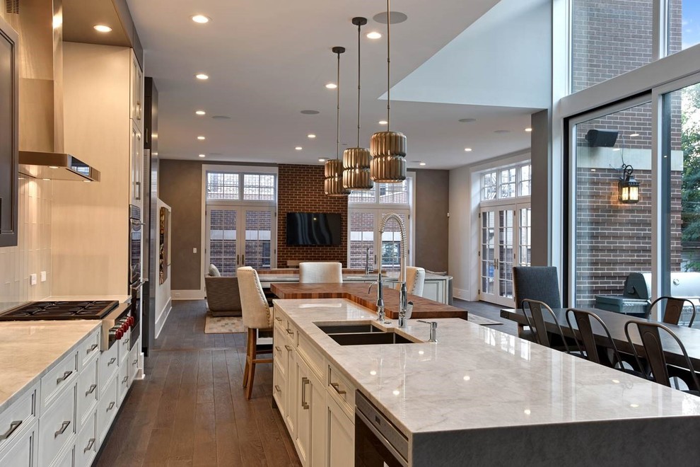 Eat-in kitchen - large transitional u-shaped medium tone wood floor and brown floor eat-in kitchen idea in Chicago with a double-bowl sink, recessed-panel cabinets, light wood cabinets, quartzite countertops, beige backsplash, glass tile backsplash, stainless steel appliances and two islands