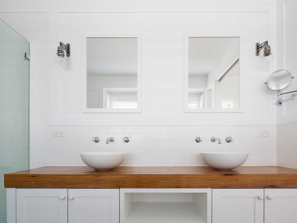 Mid-sized beach style master bathroom in Sydney with shaker cabinets, white cabinets, a corner shower, white tile, subway tile, white walls, cement tiles, a vessel sink, wood benchtops, multi-coloured floor and a hinged shower door.