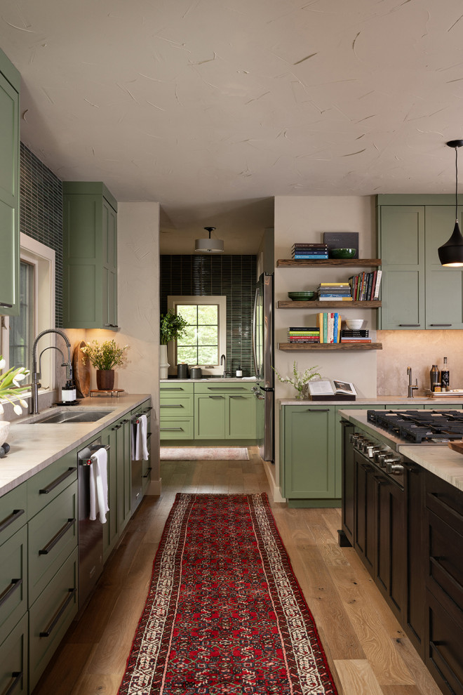 Open concept kitchen - transitional l-shaped open concept kitchen idea with an undermount sink, flat-panel cabinets, green cabinets, marble countertops, stainless steel appliances and an island