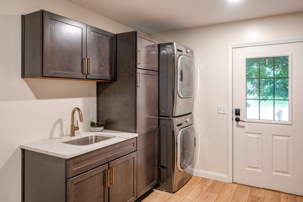 Design ideas for a mid-sized transitional u-shaped utility room in Other with an undermount sink, shaker cabinets, dark wood cabinets, quartz benchtops, red walls, vinyl floors, a stacked washer and dryer, beige floor and white benchtop.