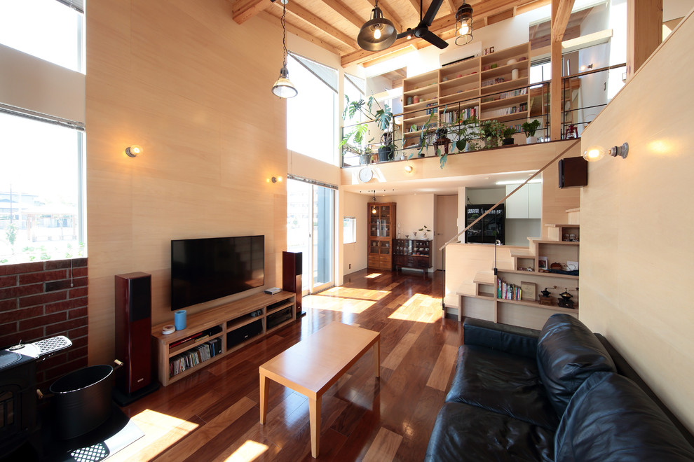This is an example of a scandinavian open concept living room in Other with beige walls, dark hardwood floors, a freestanding tv and brown floor.