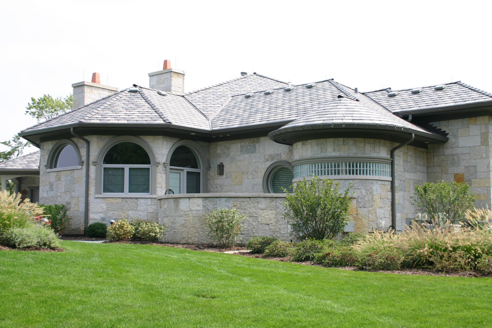 Large contemporary two-storey beige exterior in Other with stone veneer and a hip roof.
