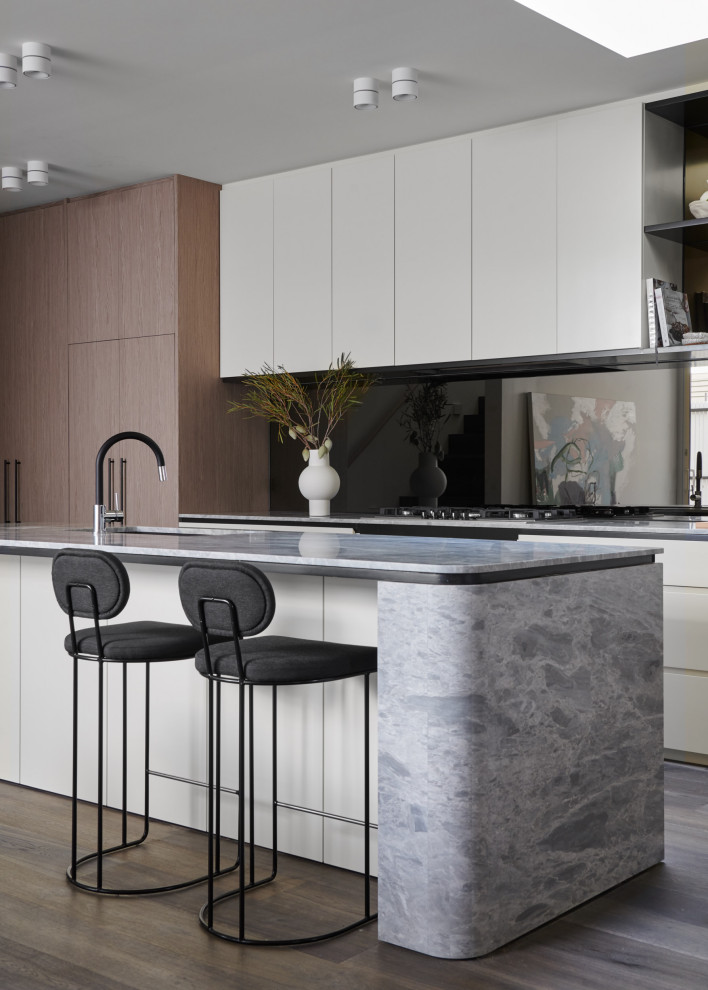 Mid-sized contemporary galley kitchen in Melbourne with a single-bowl sink, flat-panel cabinets, medium wood cabinets, black splashback, glass sheet splashback, panelled appliances, medium hardwood floors, with island, brown floor and grey benchtop.
