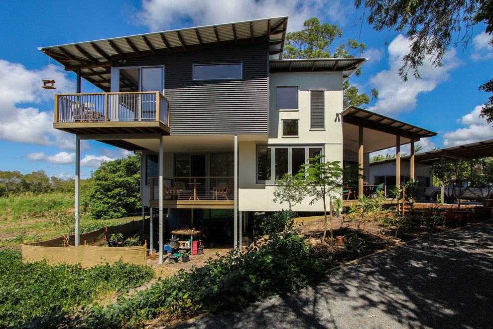Photo of a contemporary two-storey white exterior in Sunshine Coast with metal siding and a shed roof.