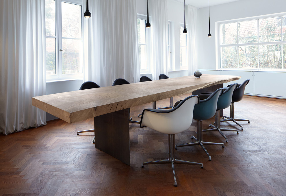 Inspiration for a mid-sized contemporary dining room in Berlin with white walls and medium hardwood floors.