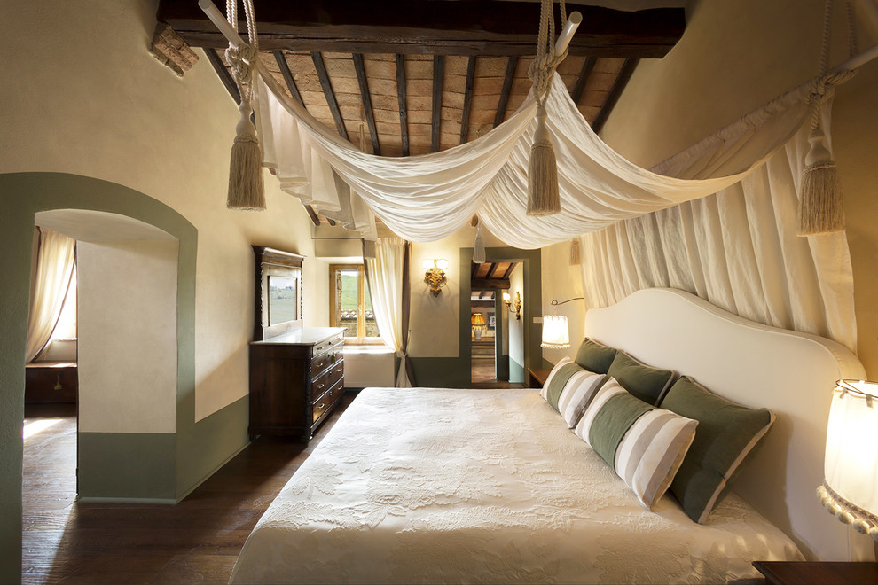 This is an example of a mediterranean master bedroom in Rome with beige walls and dark hardwood floors.