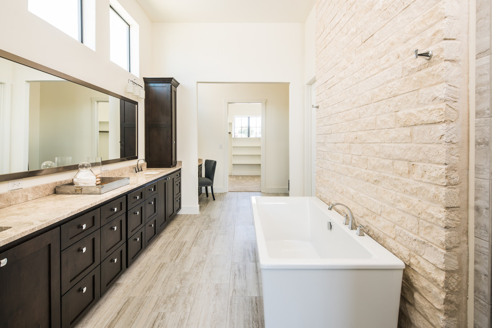 Inspiration for a large transitional master bathroom in Austin with flat-panel cabinets, brown cabinets, a freestanding tub, granite benchtops, a two-piece toilet, white walls, vinyl floors and an undermount sink.