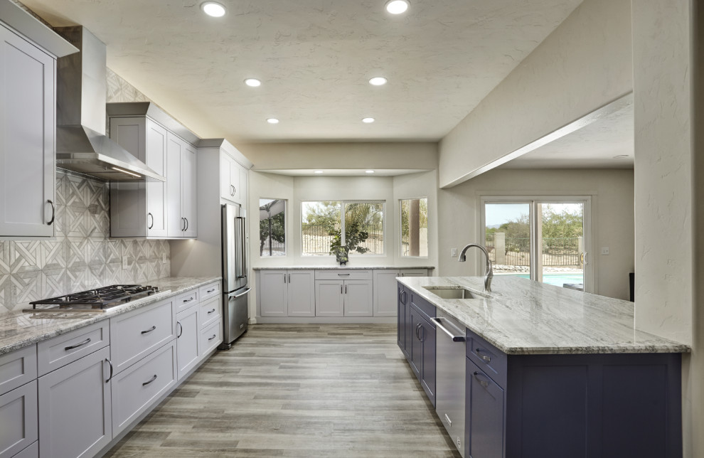 Inspiration för ett stort funkis grå linjärt grått kök och matrum, med en undermonterad diskho, skåp i shakerstil, blå skåp, granitbänkskiva, grått stänkskydd, stänkskydd i marmor, rostfria vitvaror, laminatgolv, en köksö och brunt golv