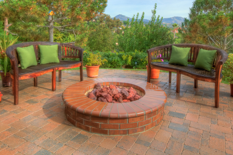Photo of a large contemporary backyard patio in San Diego with a fire feature, brick pavers and no cover.
