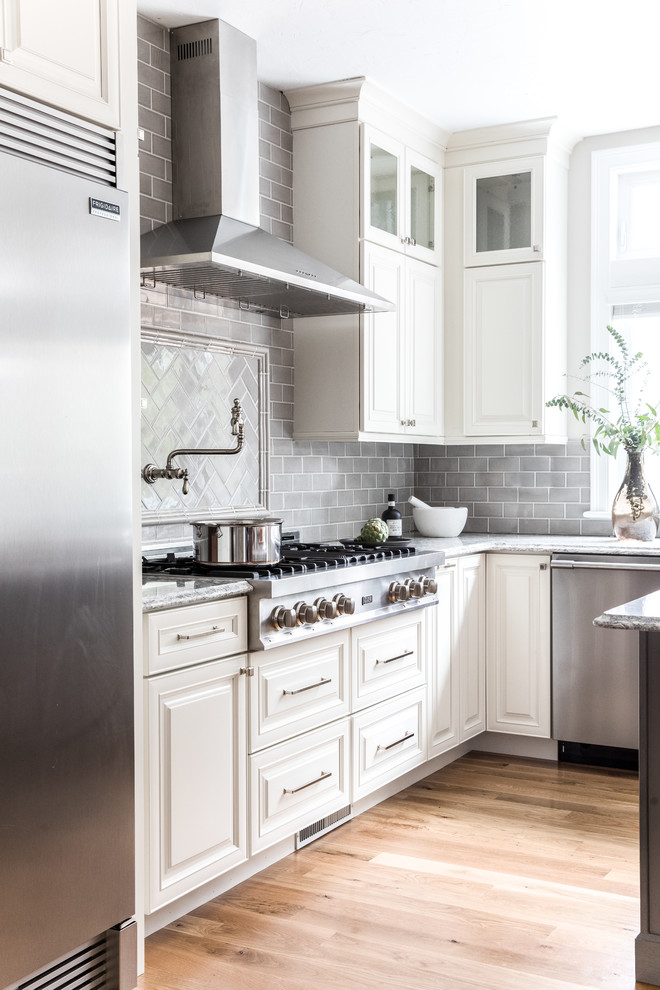 Design ideas for a transitional l-shaped open plan kitchen in Boston with a farmhouse sink, raised-panel cabinets, distressed cabinets, quartz benchtops, ceramic splashback and with island.