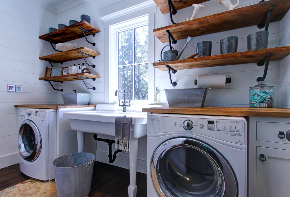 Design ideas for a country single-wall dedicated laundry room in Atlanta with an utility sink, shaker cabinets, white cabinets, wood benchtops, white walls, dark hardwood floors and brown benchtop.