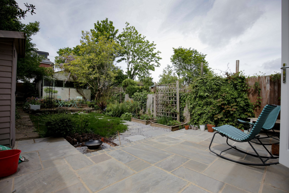 Mid-sized scandinavian backyard patio in London with a vertical garden, natural stone pavers and no cover.
