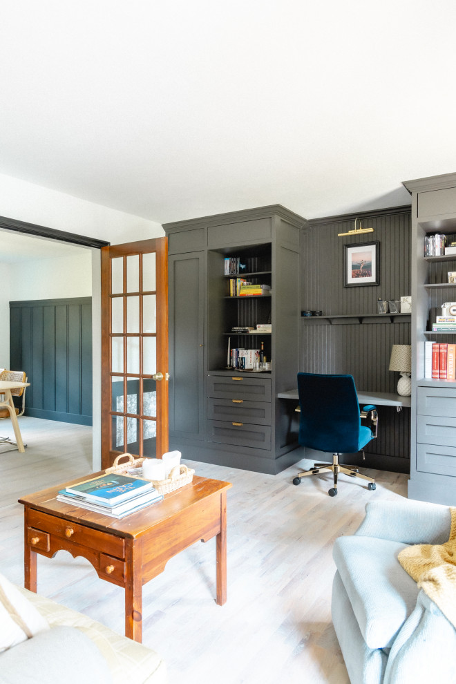 Klassisches Arbeitszimmer mit Arbeitsplatz, bunten Wänden, hellem Holzboden, Einbau-Schreibtisch, grauem Boden und vertäfelten Wänden in Sonstige