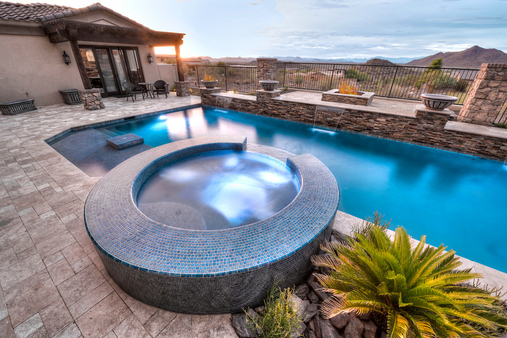 Large minimalist backyard stone and custom-shaped pool fountain photo in Phoenix