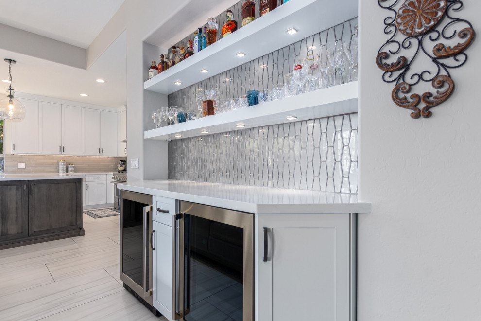 Inspiration for a transitional kitchen remodel in Phoenix with a farmhouse sink, shaker cabinets, white cabinets, gray backsplash, stainless steel appliances and white countertops