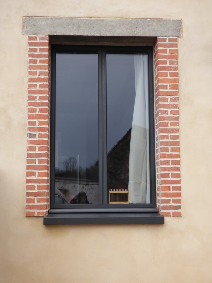 Cette photo montre façade de maison mitoyenne in brique With un toit à quatre pans and un toit mixte.