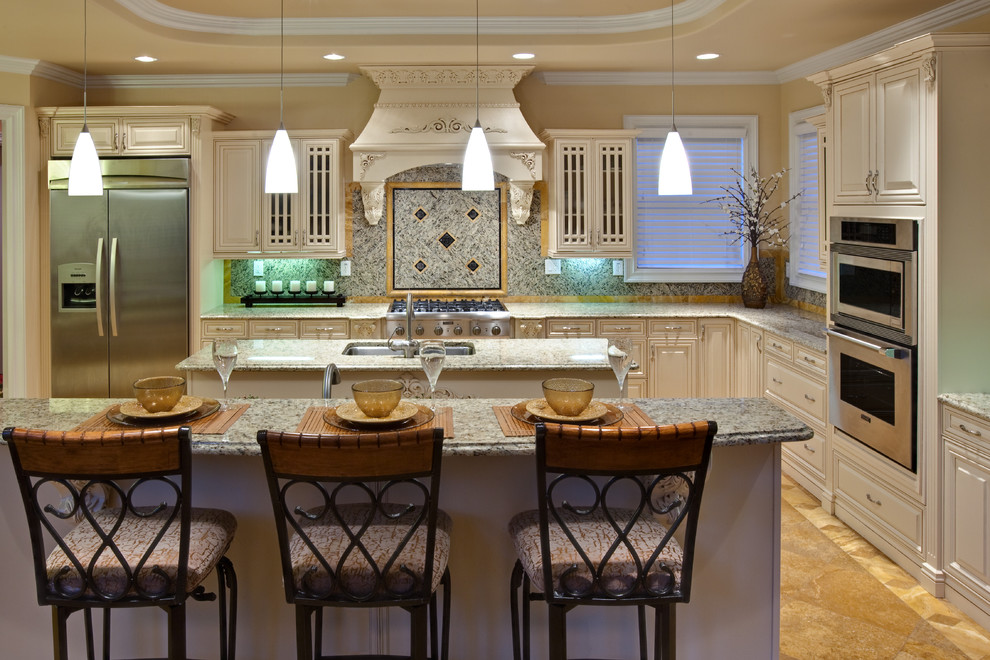 Inspiration for an expansive traditional u-shaped eat-in kitchen in Atlanta with an undermount sink, raised-panel cabinets, white cabinets, granite benchtops, multi-coloured splashback, granite splashback, stainless steel appliances, travertine floors, with island, brown floor and beige benchtop.