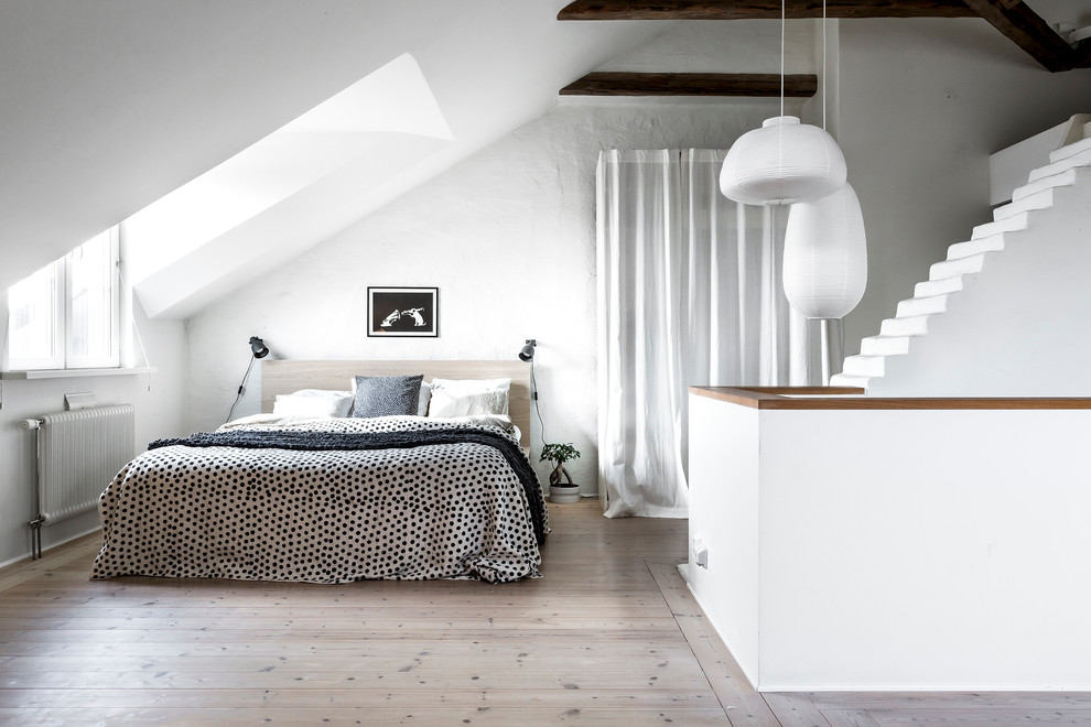 Design ideas for a mid-sized scandinavian master bedroom in Stockholm with white walls, light hardwood floors and no fireplace.