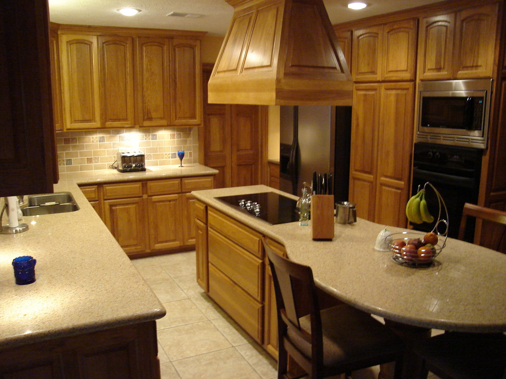 Mid-sized transitional l-shaped ceramic tile eat-in kitchen photo in Houston with a double-bowl sink, raised-panel cabinets, light wood cabinets, solid surface countertops, multicolored backsplash, subway tile backsplash, stainless steel appliances and an island