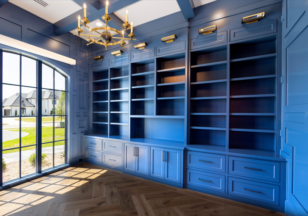 Cette photo montre un grand bureau avec un mur bleu et un bureau intégré.