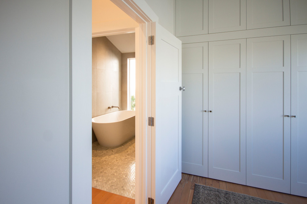 Modelo de habitación de invitados de estilo americano pequeña con paredes grises, suelo de madera clara, vigas vistas y panelado