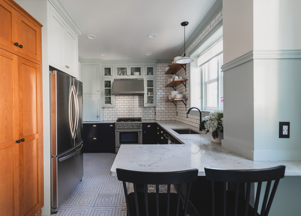 Inspiration for a mid-sized traditional l-shaped separate kitchen in Philadelphia with an undermount sink, recessed-panel cabinets, black cabinets, quartz benchtops, white splashback, ceramic splashback, stainless steel appliances, painted wood floors, a peninsula, blue floor and white benchtop.