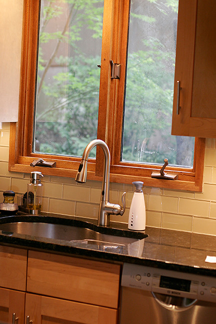 Eat-in kitchen - small transitional l-shaped porcelain tile eat-in kitchen idea with shaker cabinets, light wood cabinets, granite countertops, beige backsplash, glass tile backsplash, stainless steel appliances and a peninsula