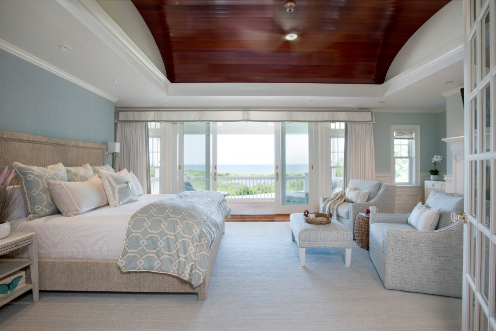 Example of a large beach style master medium tone wood floor and brown floor bedroom design in Boston with blue walls