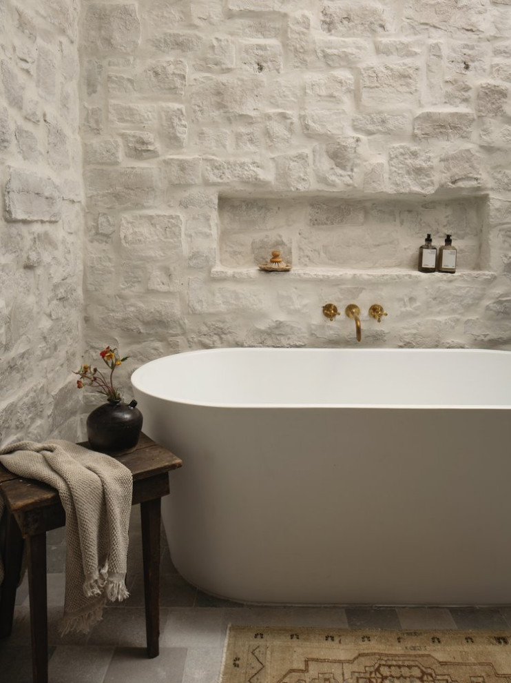 Example of a transitional white tile freestanding bathtub design with a niche