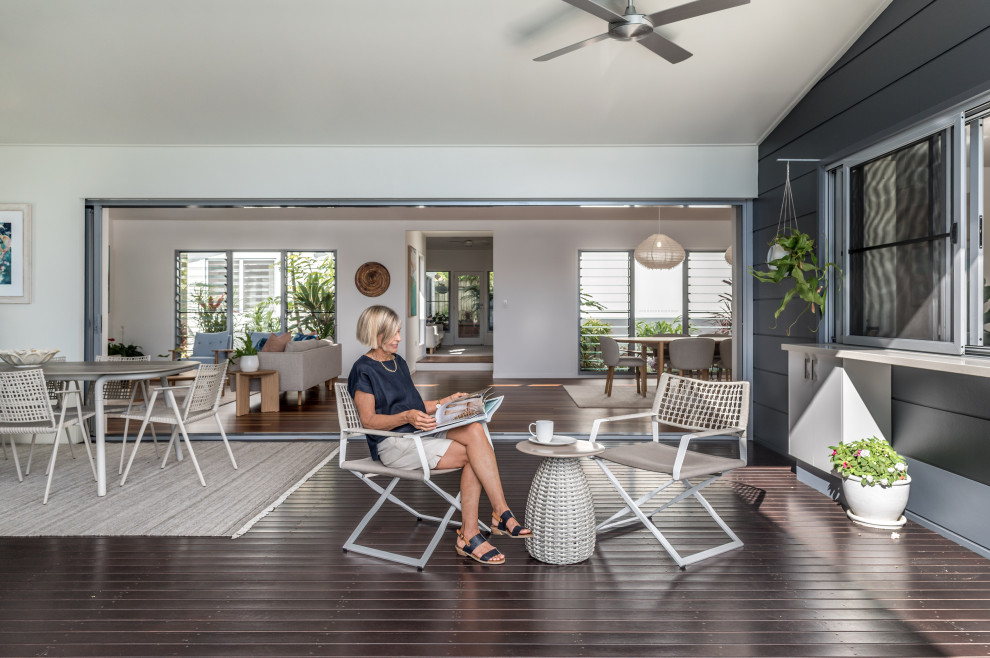 Design ideas for a large beach style backyard deck in Sunshine Coast with a roof extension.