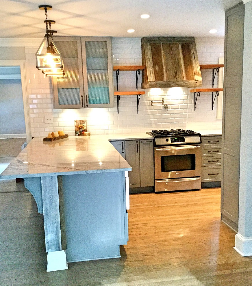 Example of a mid-sized mountain style u-shaped light wood floor open concept kitchen design in Atlanta with a farmhouse sink, shaker cabinets, gray cabinets, quartzite countertops, white backsplash, subway tile backsplash, stainless steel appliances and a peninsula