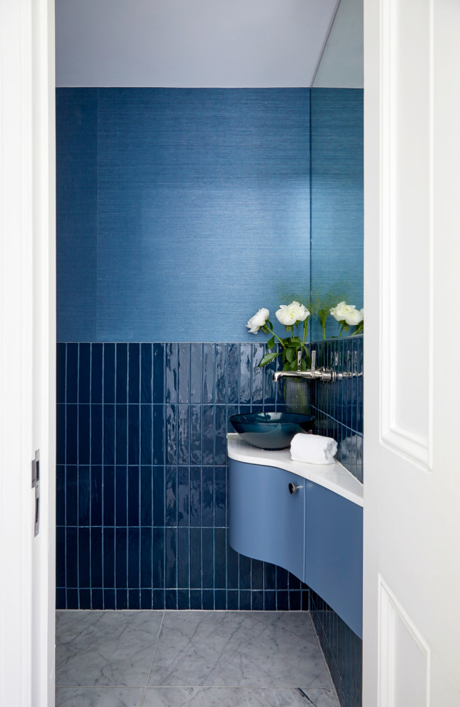 Inspiration for a small contemporary cloakroom in London with flat-panel cabinets, blue cabinets, a wall mounted toilet, blue tiles, metro tiles, blue walls, porcelain flooring, a built-in sink, engineered stone worktops, white floors, white worktops and a floating vanity unit.