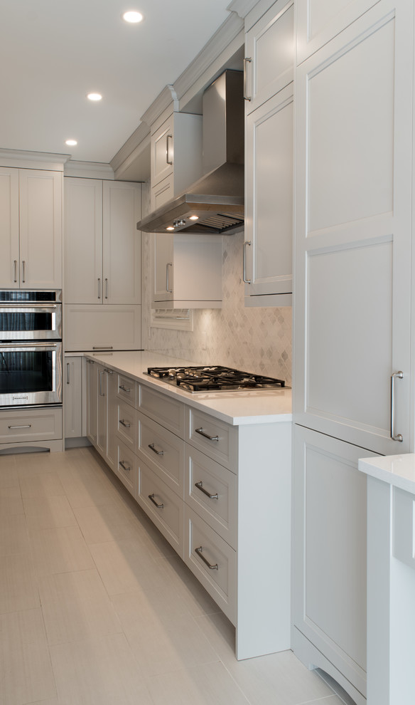 Design ideas for a large transitional l-shaped eat-in kitchen in Toronto with an undermount sink, shaker cabinets, grey cabinets, quartz benchtops, white splashback, marble splashback, stainless steel appliances, porcelain floors, with island, beige floor and white benchtop.