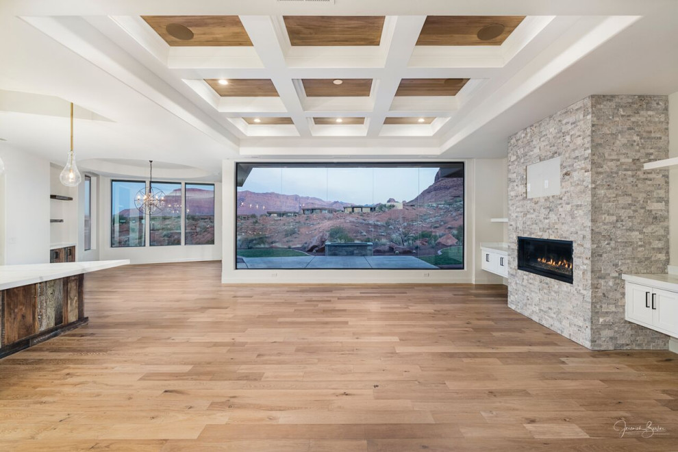 Imagen de salón abierto minimalista grande con chimenea lineal, piedra de revestimiento, televisor colgado en la pared y bandeja