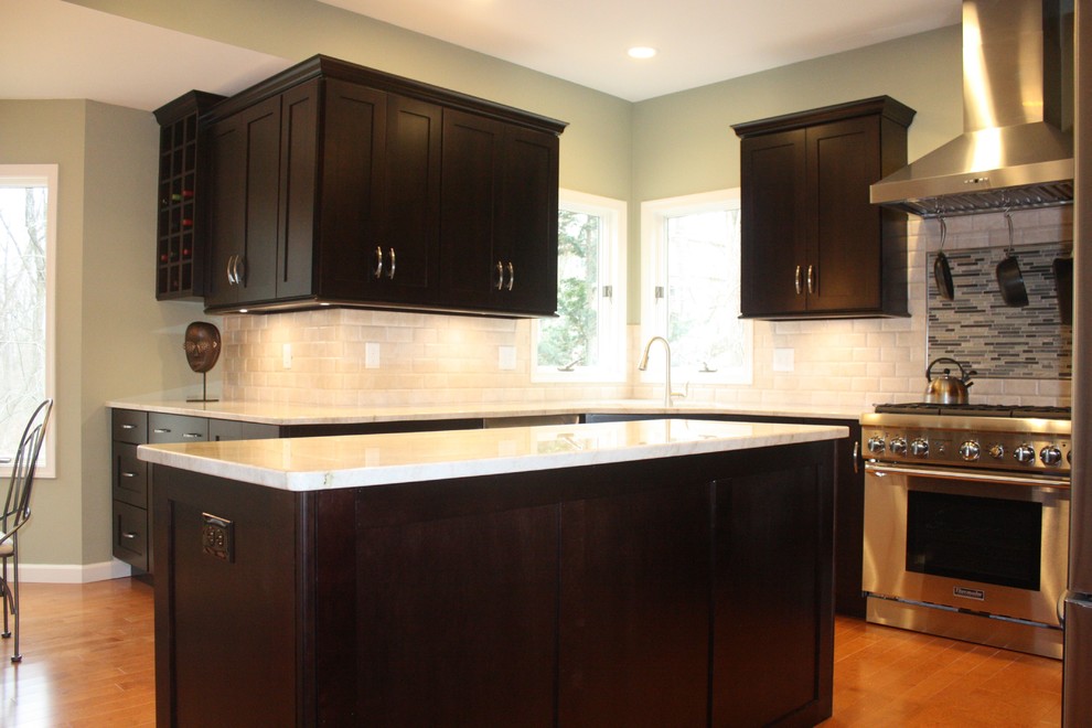 Mid-sized minimalist u-shaped medium tone wood floor kitchen photo with shaker cabinets, dark wood cabinets, white backsplash, stainless steel appliances and an island