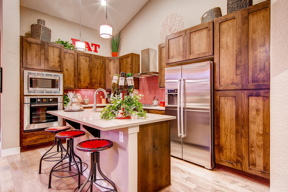 Inspiration for a traditional l-shaped kitchen in Denver with stainless steel appliances, red splashback, mosaic tile splashback, shaker cabinets and medium wood cabinets.