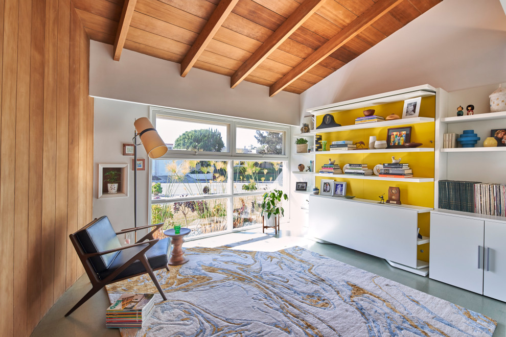 Mid-sized midcentury home office in San Diego with white walls, cork floors, a built-in desk, grey floor and wood walls.