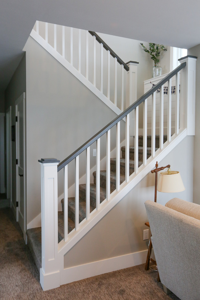 Inspiration for a large transitional carpeted u-shaped wood railing staircase remodel with carpeted risers