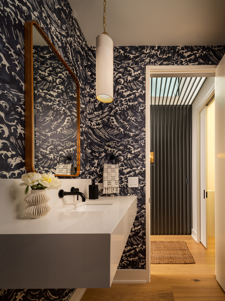 Immagine di un bagno di servizio design con pavimento in legno massello medio, top in quarzo composito, top beige, mobile bagno sospeso e carta da parati